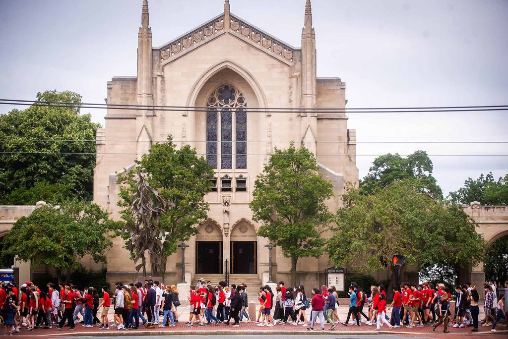 Members of the Boston University Class of 2025 walk past Marsh Chapel on Commonwealth Ave towards their Matriculation Ceremony at Agganis Arena.