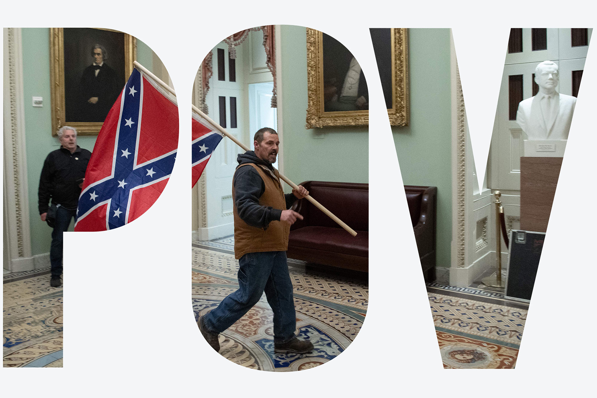 Photo of a supporter of US President Donald Trump, dressing in jeans, a tan vest and sweatshirt, carrying a Confederate flag in the US Capitol Rotunda during the insurrection on January 6, 2021, in Washington, DC. Behind him, a security guard looks on. Overlay reads "POV"