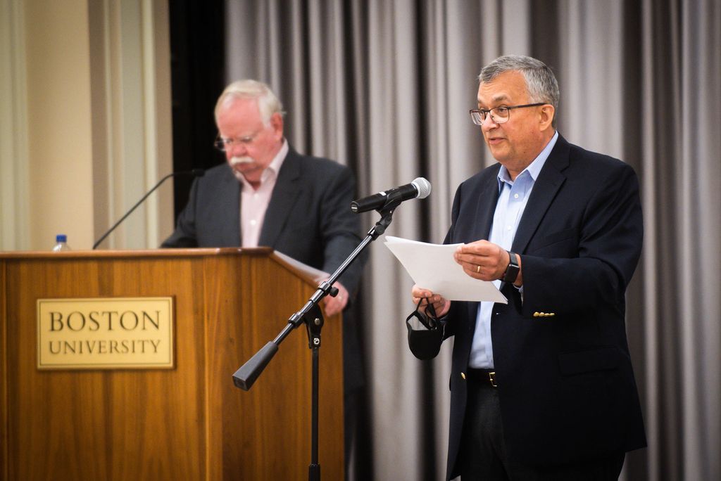 Photo of Gary Nicksa, in a suit, speaking at a microphone and holding a piece of paper, as he begins the town hall meeting which addressed the fall semester and remote work during a town hall meeting on August 19, 2021.