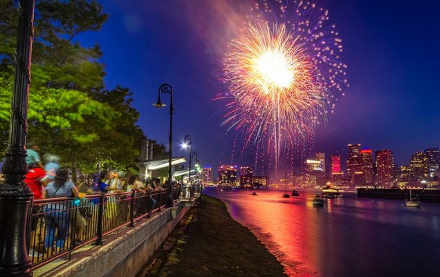 Spectators watch fireworks explode in the sky along the Boston Harbor waterfront