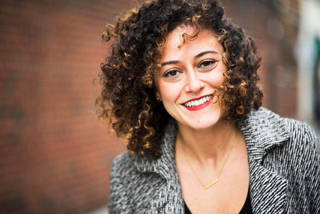 Portrait of Danielle Letayf, founder of the start-up business Badassery, outside with a brick wall in the background.