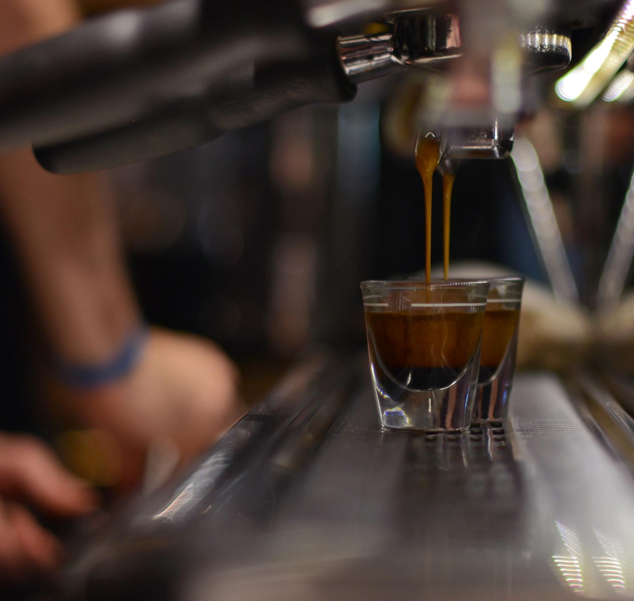 close-up photo of double espresso shots being poured from espresso machine in Pavement Coffeehouse.