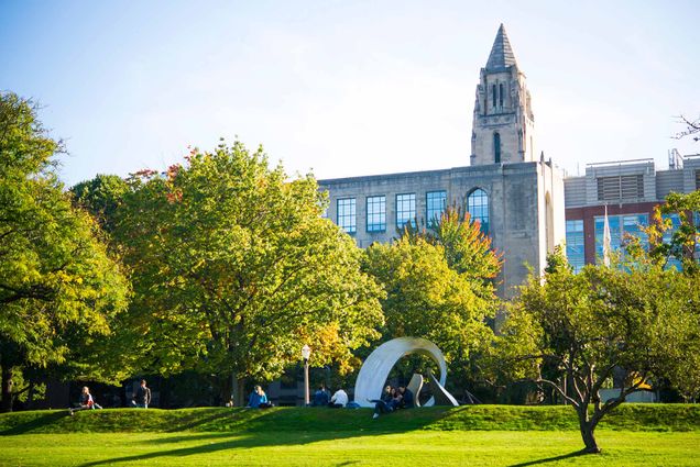 Early Fall view of a green BU Beach wtih the College of Arts & Sciences building in the background.