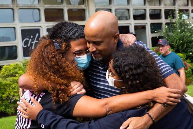 A familly embraces in a big hug saying goodbye after moving their child into dorms for the fall semester at Boston University