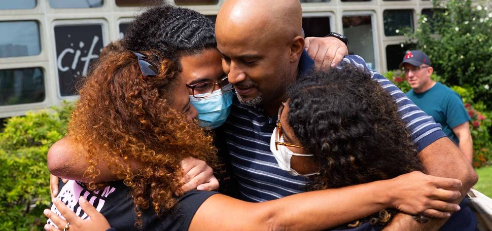 A familly embraces in a big hug saying goodbye after moving their child into dorms for the fall semester at Boston University
