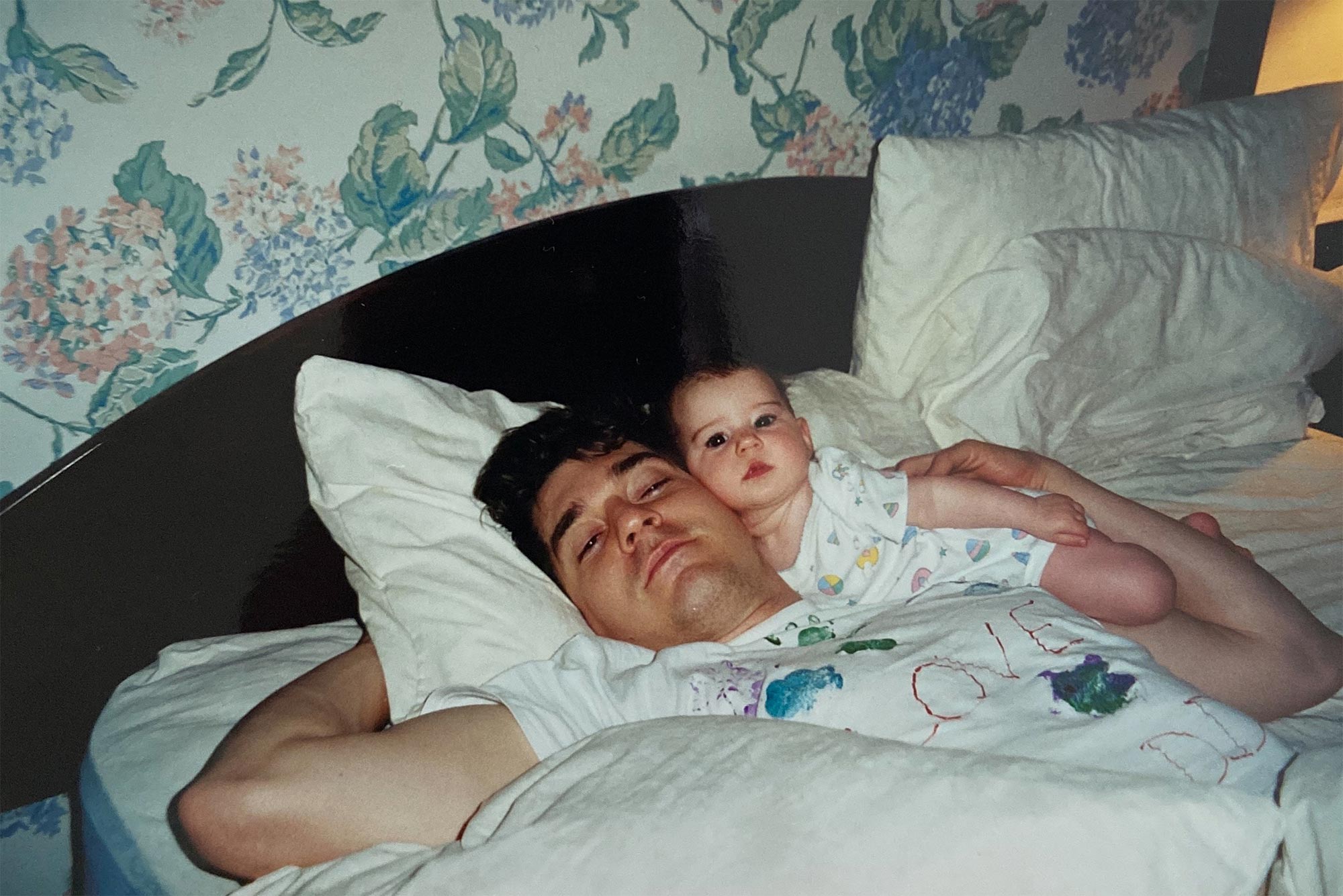 Photo of a printed photo of Halie Metz as a baby, laying on a bed with her father before he was killed on 9/11.