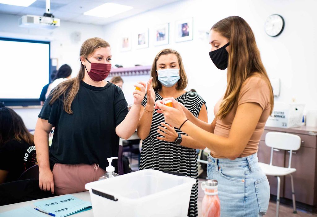 Three students wearing face masks work together during a graduate Skills class at Sargent College.