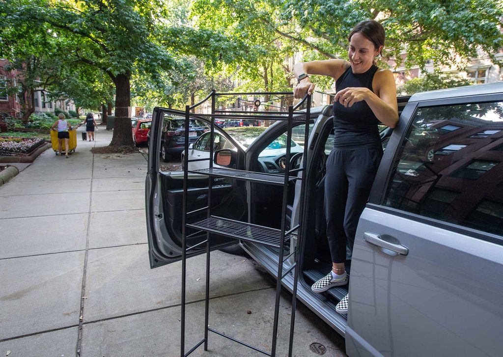 Candi Welch assembles a display shelf for her niece Addison Cummings (COM’25, KHC’25), while Cummings moves into Kilachand Hall August 27. Welch chose to assemble it outside in the shade because of the tight quarters in the dorm, and the two person limit. 