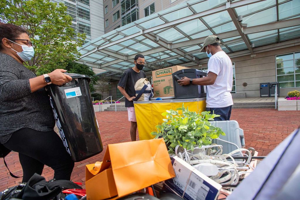 Ryan Ramlogan (COM’22), center, fills his move in bin at Stuvi2 with the help of his aunt Krystle Ramdhanie, at left, and his uncle Sheldon Ramdhanie August 16