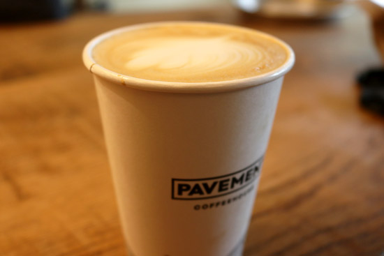 photo of hot latte with leaf latter art in the foam