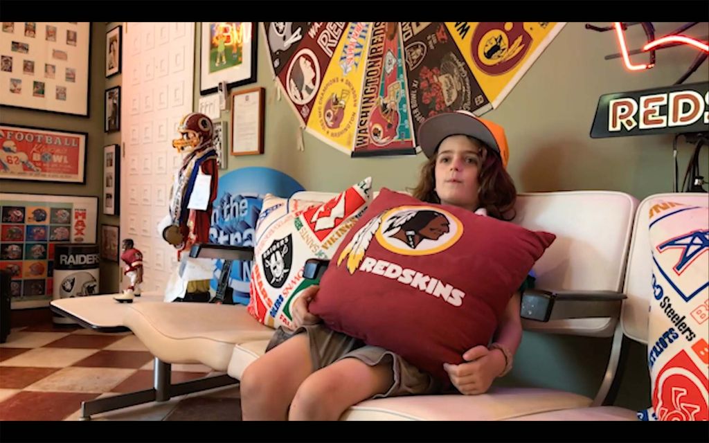 a photo oof Cary’s son, Otis, in their game room before it was stripped of Washington football memorabilia