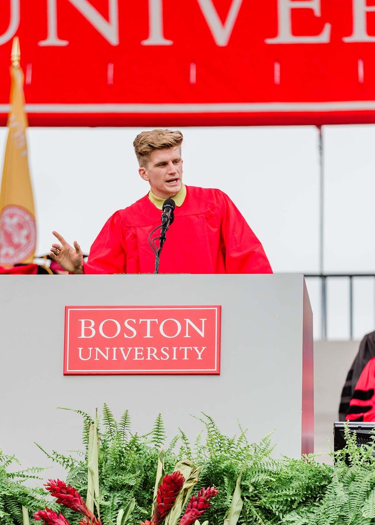 Photo of student speaker Macken Murphy (CAS’20), in his red gown, speaking at the podium.