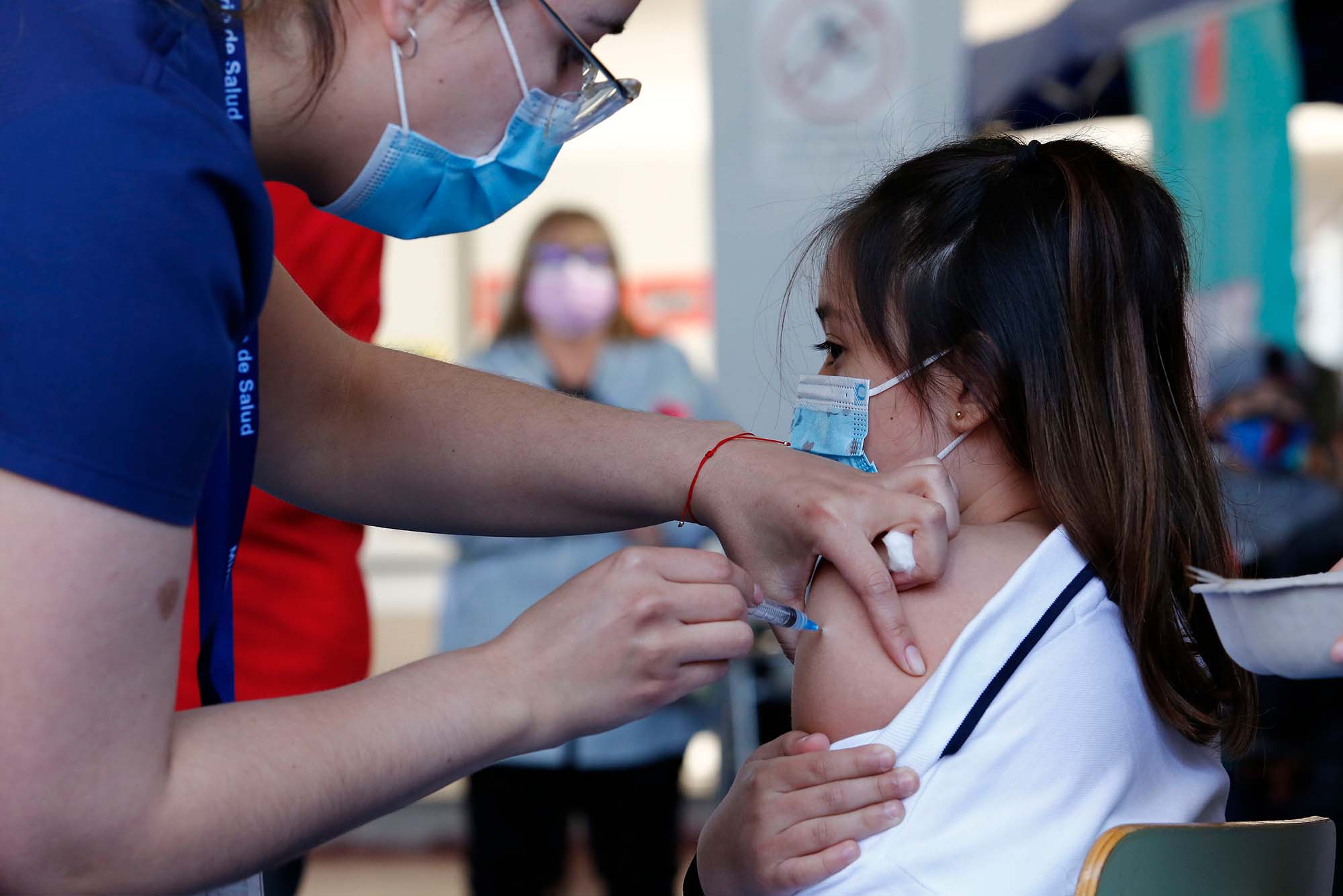 A school girl in Ecuador, age 6-11, receives a shot of the Sinovac COVID-19 vaccine.