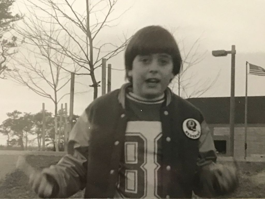 sepia photo of Donick Cary (CGS’88) as a child wearing an old Washington football jersey