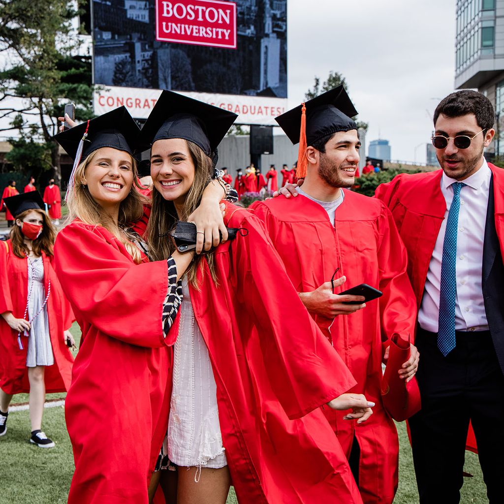 Two students smile and pose for a photo while celebrating on Nickerson Field following BU's Class of 2020 Commencement.