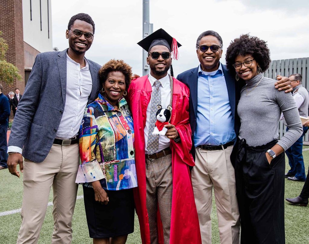 A Black family poses for a photo with their BU Class of 2020 graduate following Boston University's 147th Commencement ceremony on Nickerson Field.