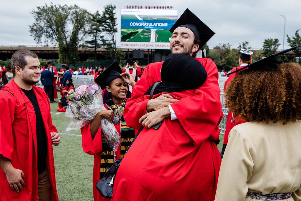 BU Class of 2020 students celebrate following their graduation ceremony. Two students are hugging.