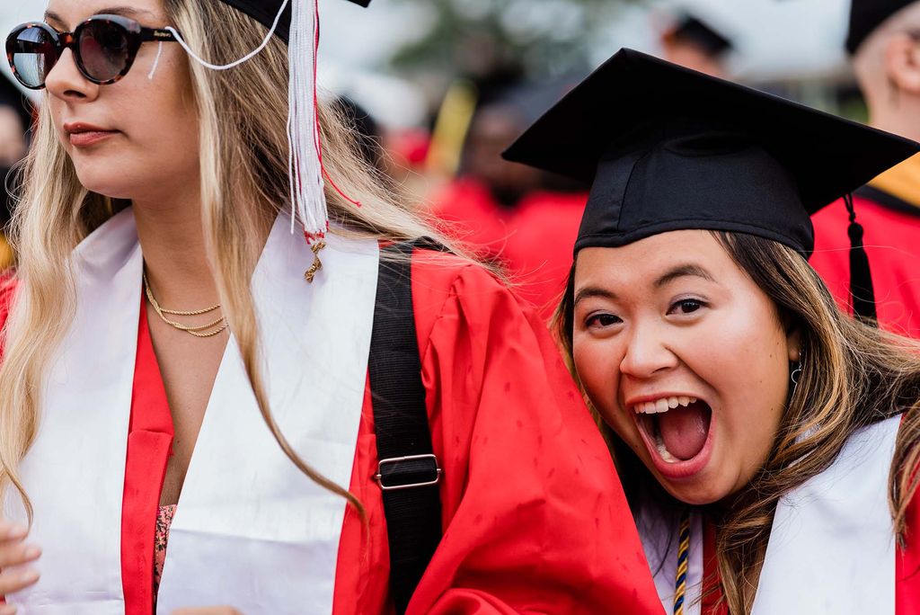 A graduating student poses for a photo during Commencement.