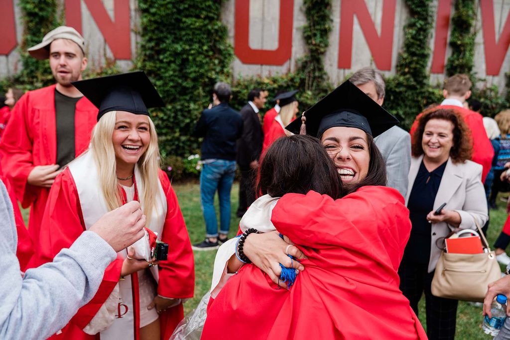 Two students embrace in a celebratory hug after Boston University's Class of 2020 graduation.