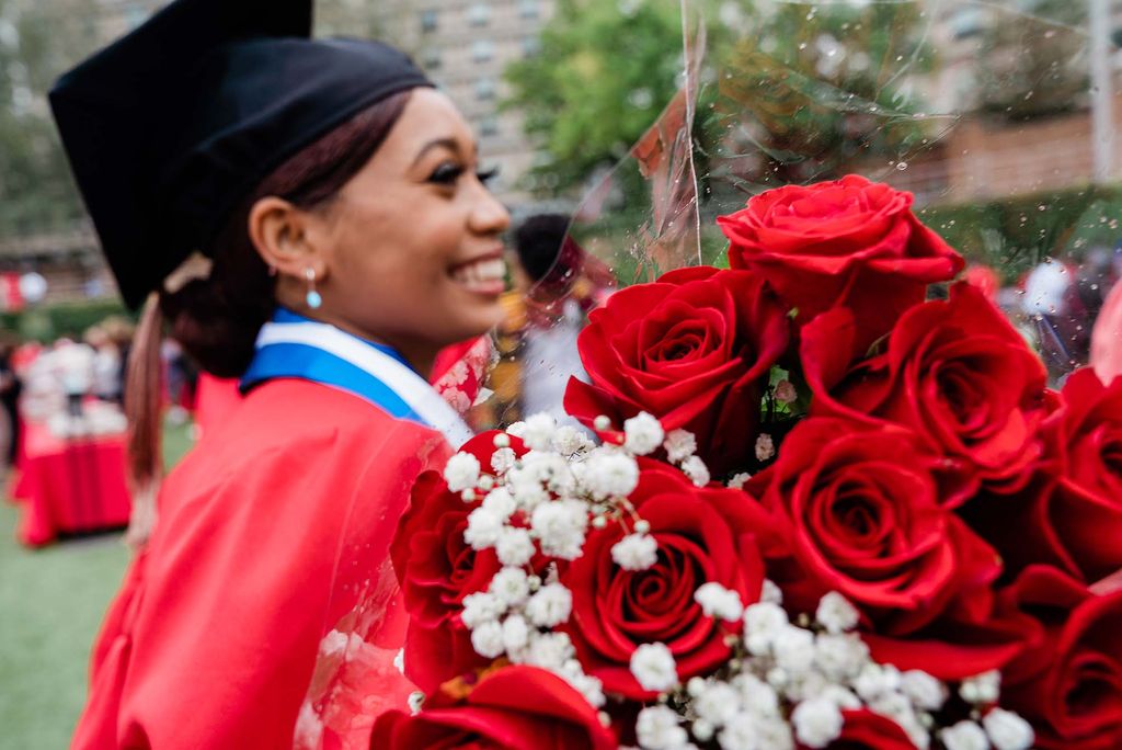 A student carries a bouquet of red roses following the BU Class of 2020 Commencement.