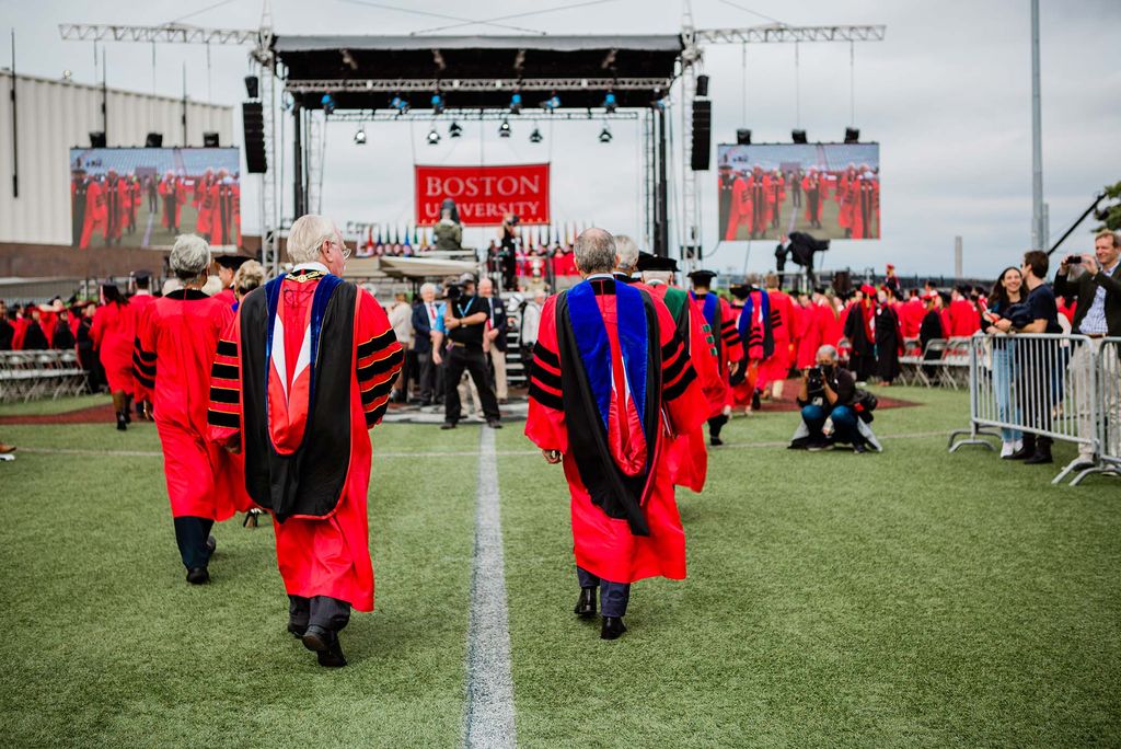 Faculty and staff walk towards the stage as Boston University's Class of 2020 Commencement begins.