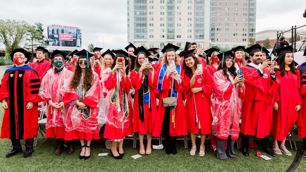 A section of Class of 2020 graduating students stand and take photos during BU's 147th Commencement ceremony.