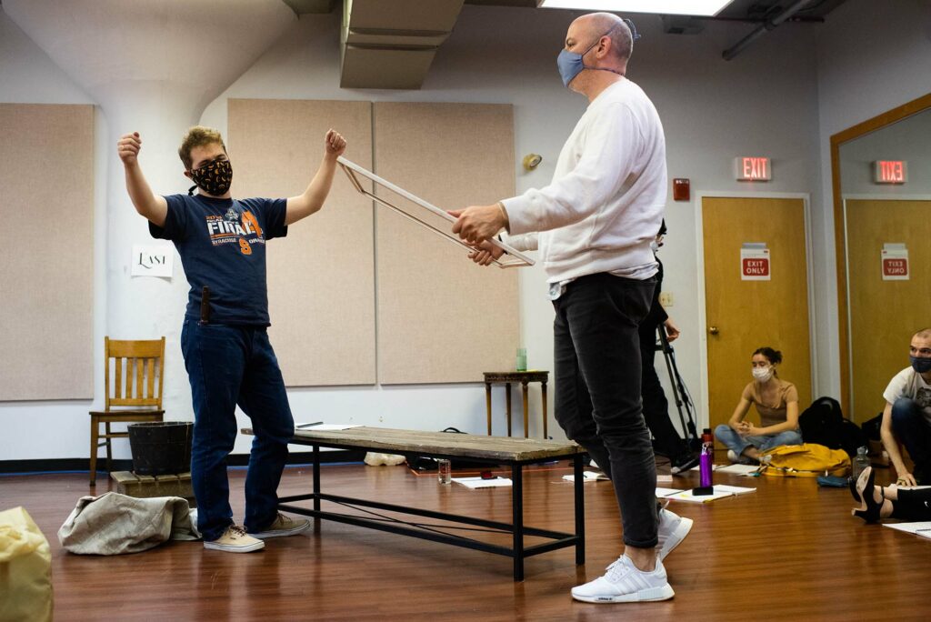 Jacob O’Shea (CFA’21,’23) (left) and stage director Nathan Troup (CFA’04) during a rehearsal of Proving Up. Troup stands with a window pane in his hands.