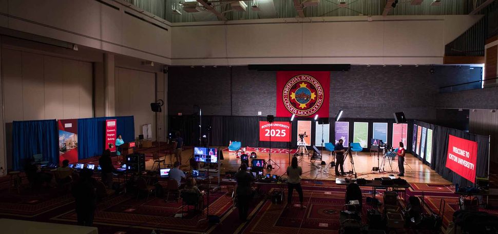 Setting up the stage for remotely broadcast student orientation session in Metcalf Hall.
