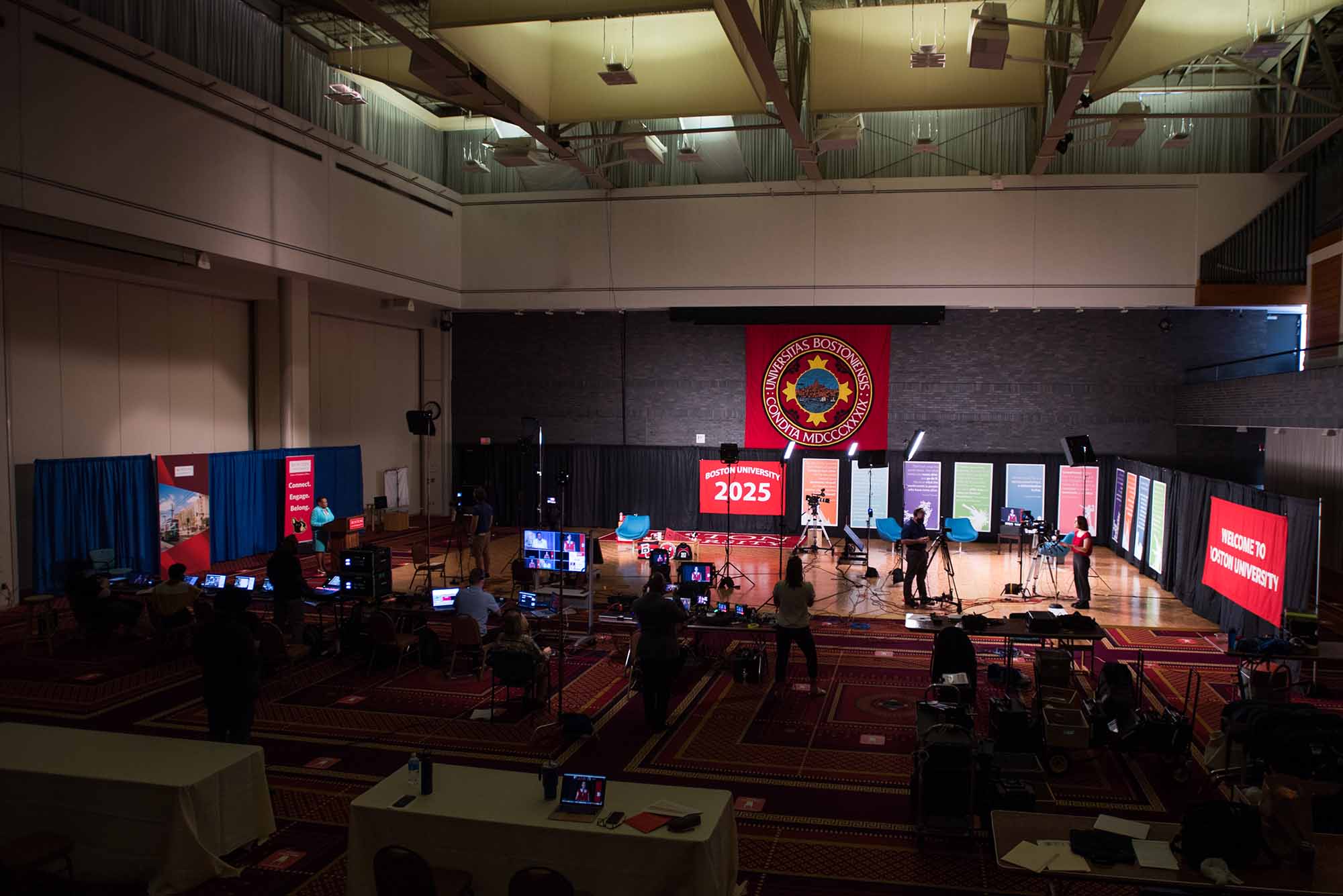 Setting up the stage for remotely broadcast student orientation session in Metcalf Hall.