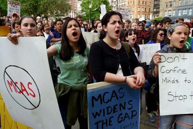 a photo of students chanting and holding signs at a protest against the Massachusetts Comprehensive Assessment System exam on Boston Common.