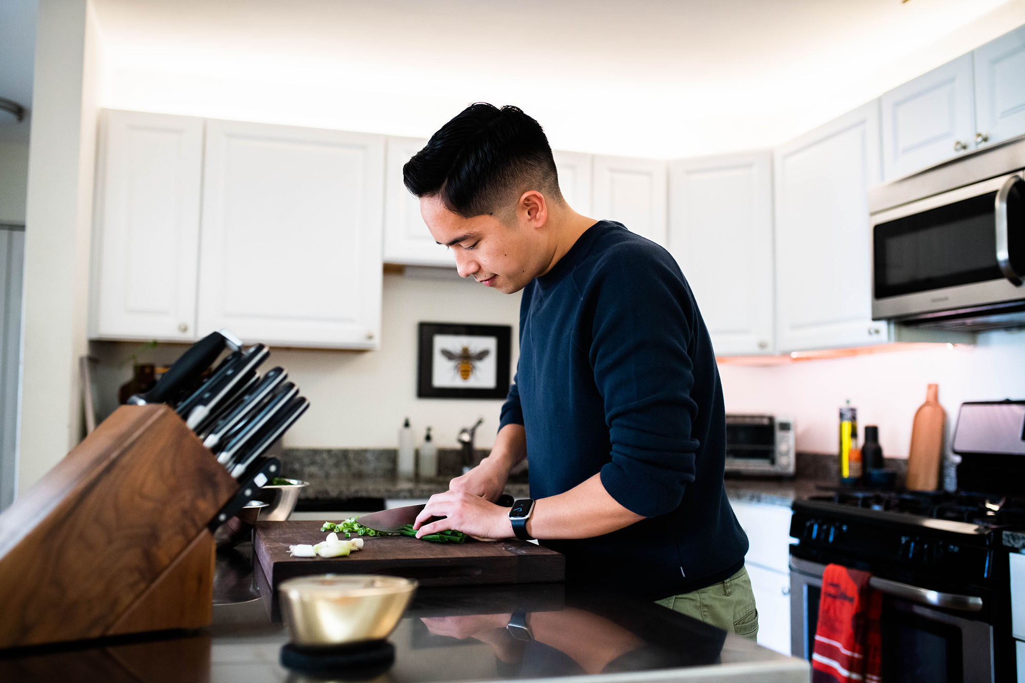 Matt Bae, a student advisor in the College of General Studies appreciates being able to chop vegetables in his kitchen on his lunch break for the healthy dinner he’ll prepare when he’s done work. 
Photo by Jackie Ricciardi 