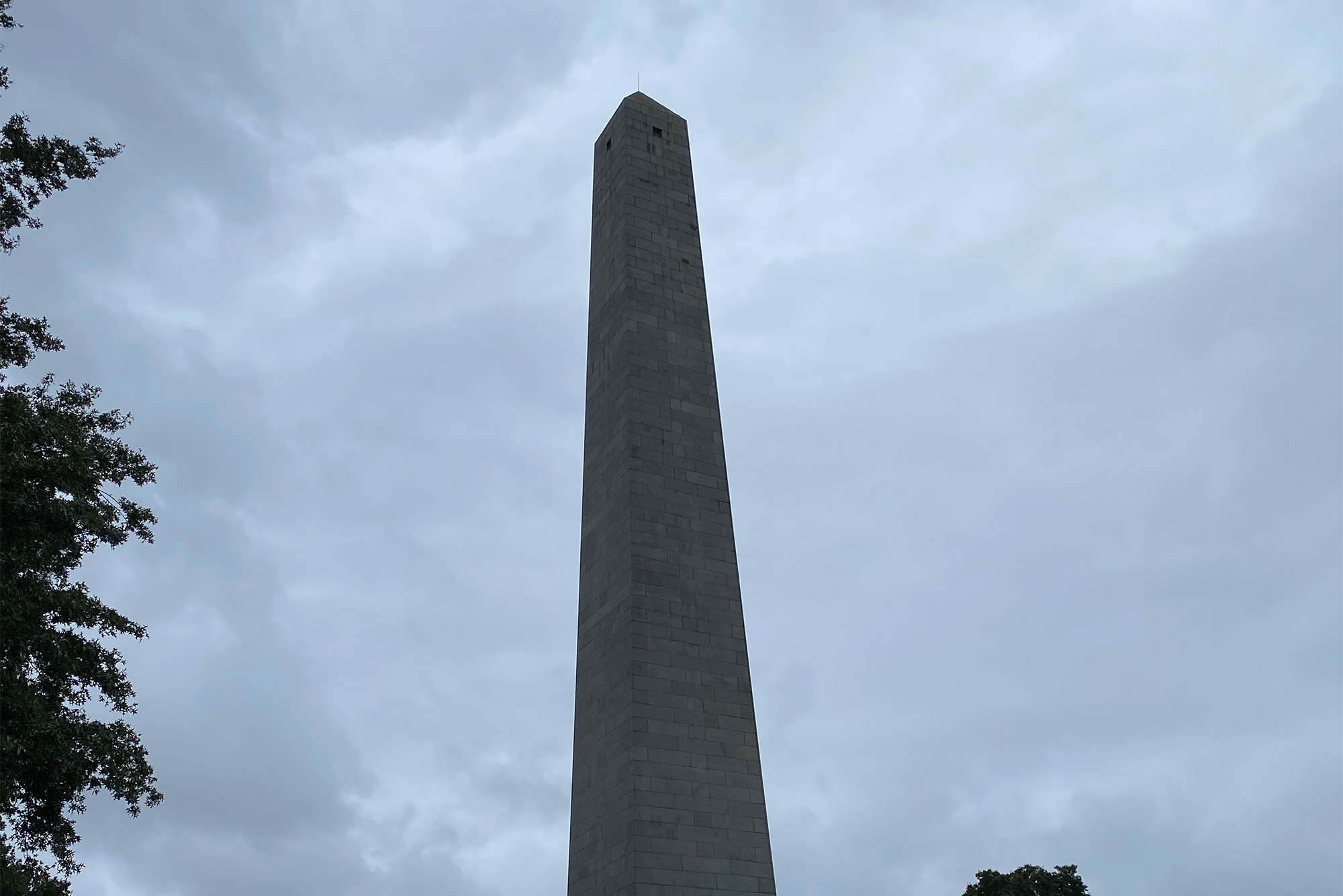 Bunker Hill Monument stands tall on a cloudy day in Charlestown, MA