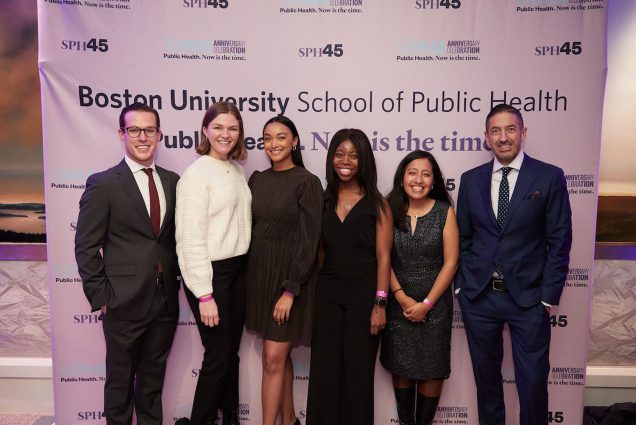 a photo of Sandro Galea and Robert A. Knox posing with six SPH student scholarship recipients who were honored at the school's 45th Anniversary Celebration. From Left to Right: Dean's Scholar Jose Antonio Requejo (SPH'22), Outstanding Scholar Samantha Burkhart (SPH'22), Dean's Scholar Nicole Herrera (SPH'24), Dean's Scholar Tomeka Frieson (SPH'23), and Robert F. Meenan Scholar Lesly Zapata (SPH'23). All are in formal wear and smile at the camera.