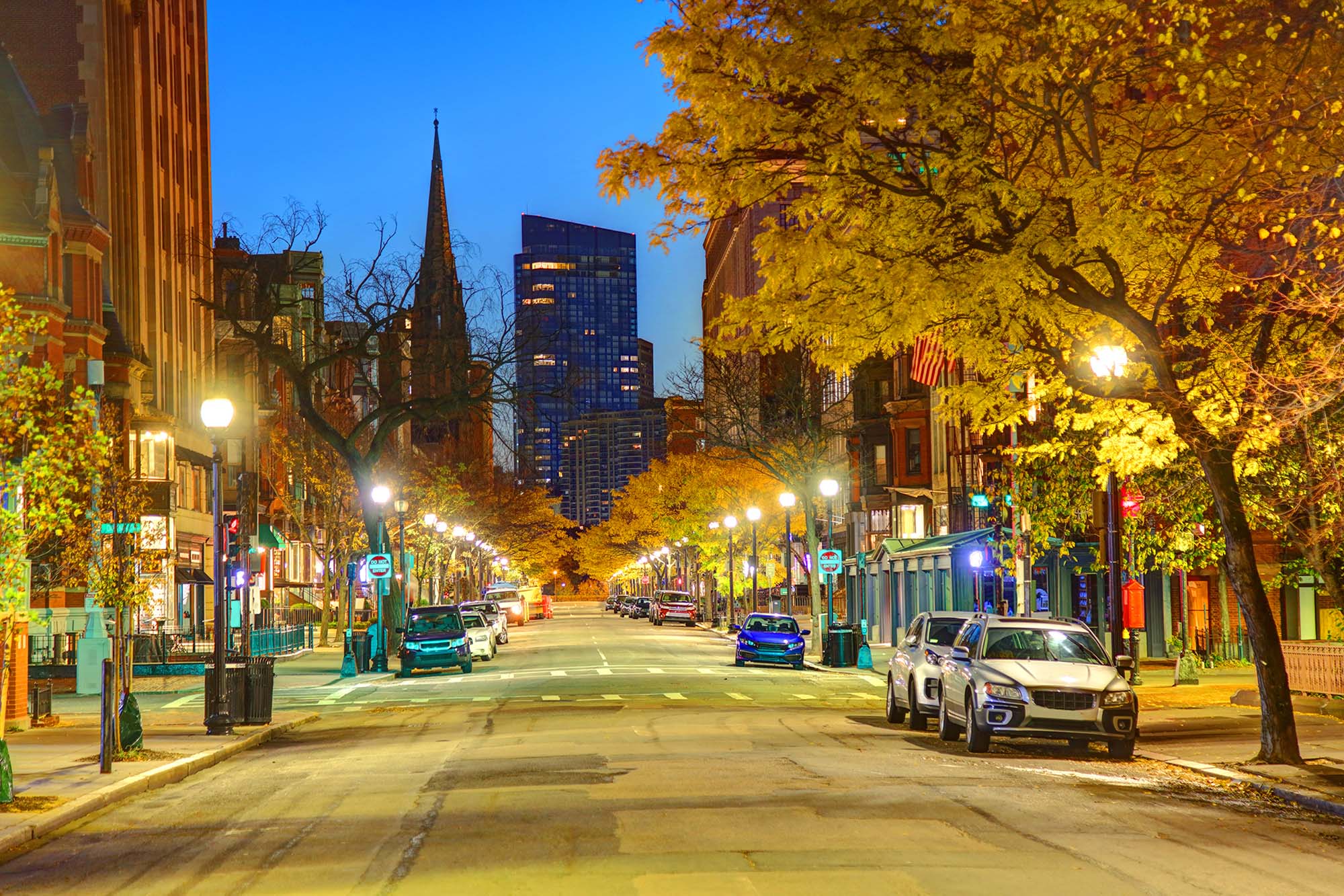 photo of Newbury Street, Boston during dusk. The fall leaves and street are surrounded by a golden glow as the sun sets.