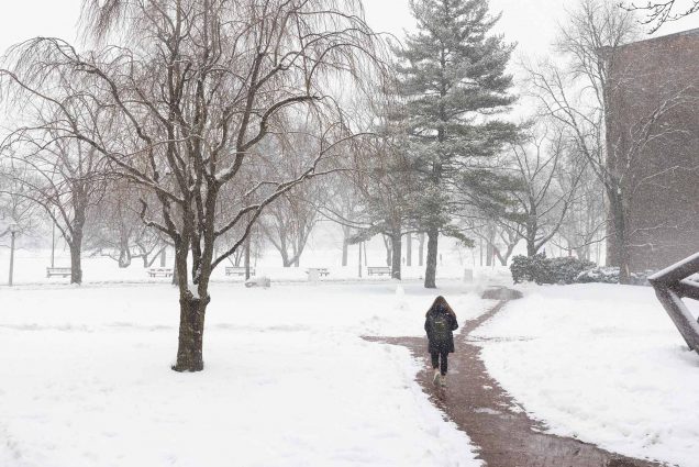 photo of a lone student walking through the snow on the BU Beach Tuesday morning
