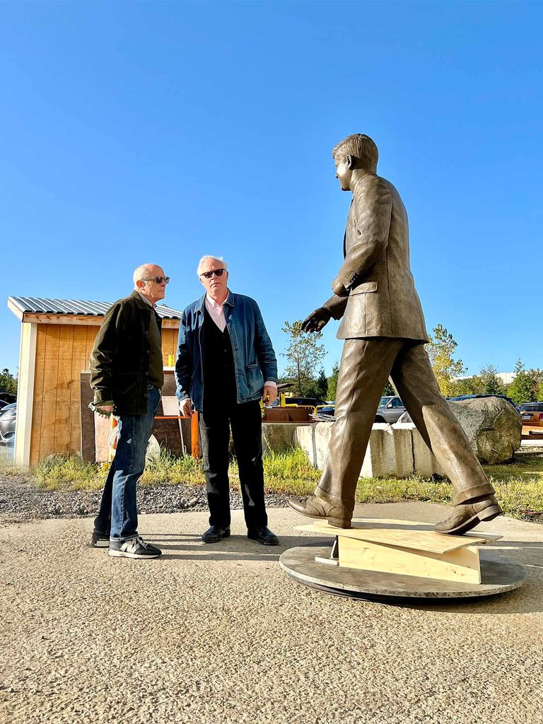 Brothers Ivan and Elliot stand in front of a JFK statue their foundry created
