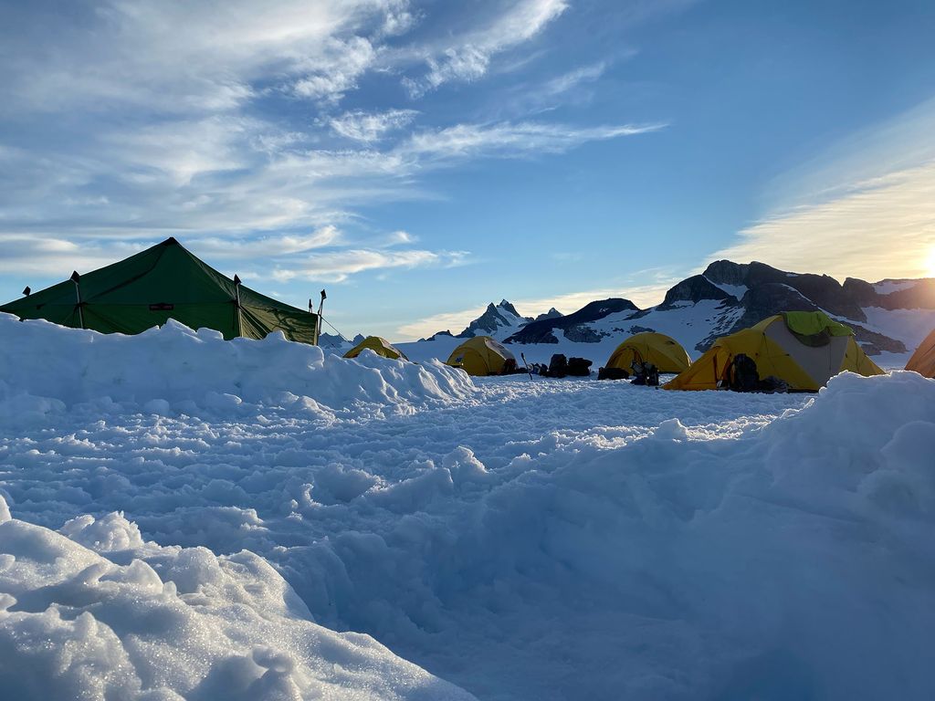 photo of a remote camp on the icefield the researchers skied to. Tents are seen in mountains of snow