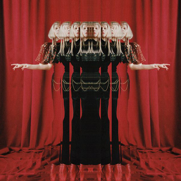 Album cover of AURORA's "The Gods We Can Touch". Cover features an image of Aurora in front of a dark red curtain. The image is distorted and layered on top of itself, as if looking through a fun house mirror and seeing multiple at once.