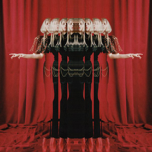 Album cover of AURORA's "The Gods We Can Touch". Cover features an image of Aurora in front of a dark red curtain. The image is distorted and layered on top of itself, as if looking through a fun house mirror and seeing multiple at once.