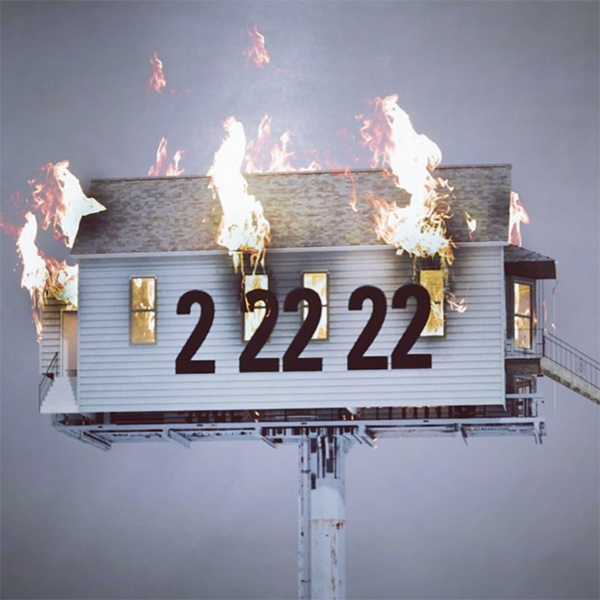 Image of a small, white house on fire. It appears to be in the sky on a large pole and the numbers "2 22 22" are shown in large block font over the house.