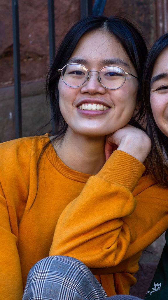 photo of Untangle Magazine’s creators Emily Wu (left) and Alyssa Yeh, 2 Asian American women. They sit on a brownstone stoop and smile to the camera.