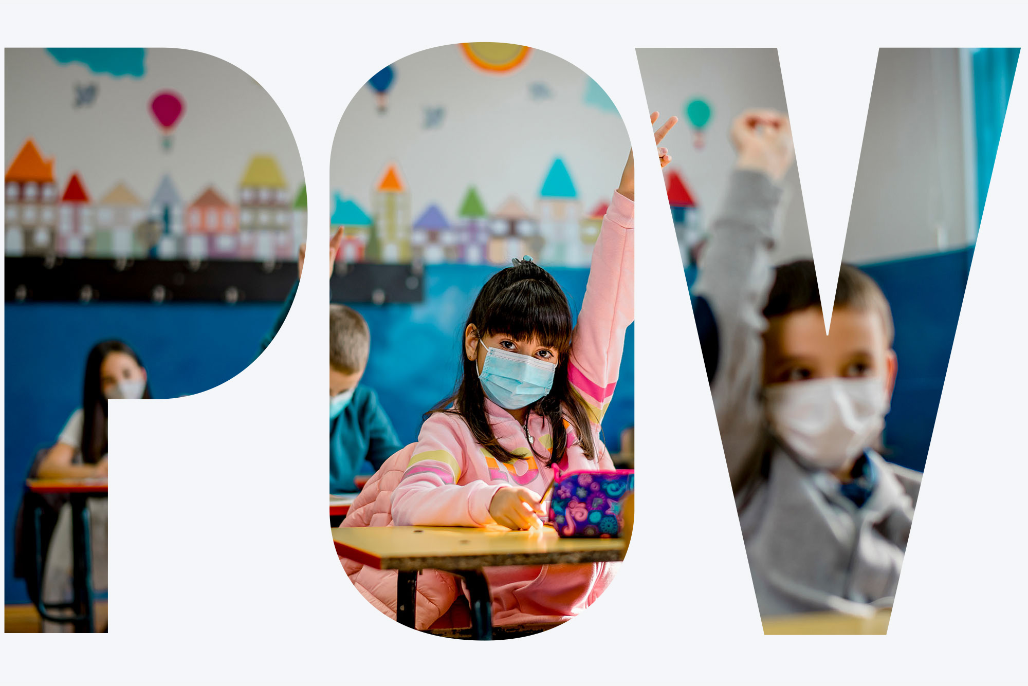 A child wearing a mask raises their hand in a classroom