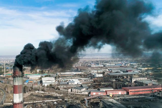 smoke spews out of a coal power plant smokestack in an unknown location