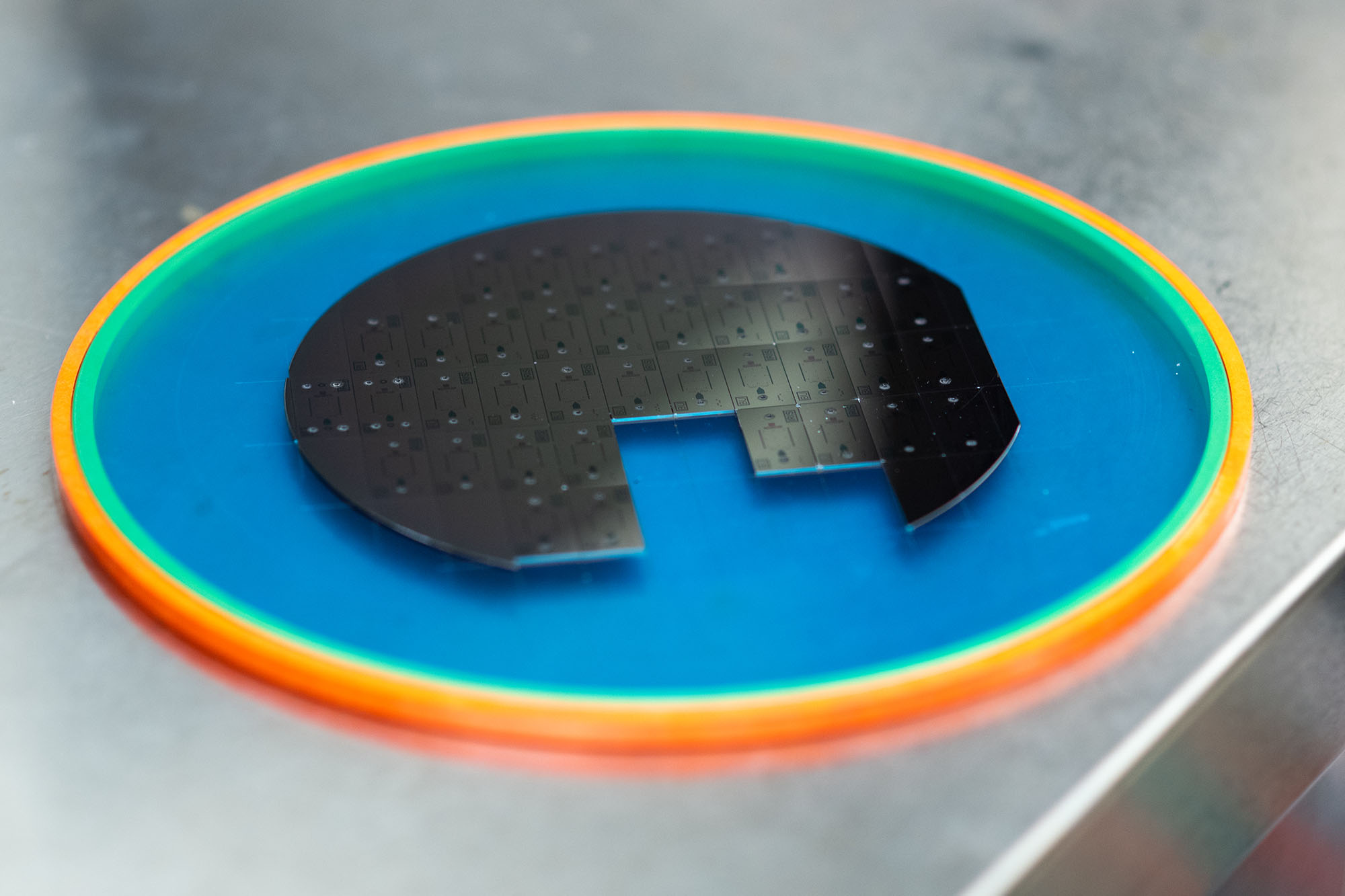 Photo of the  microchips used in Selim Unlu's lab. Discs are atatched together and placed on a rainbow mat.
