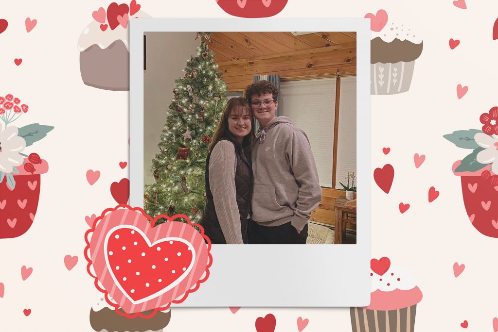 Image: Polaroid style photo of 2 white people posing together as they smile for the camera. Polaroid is placed on a tan background of red and pink hearts, cupcakes, and flowers.