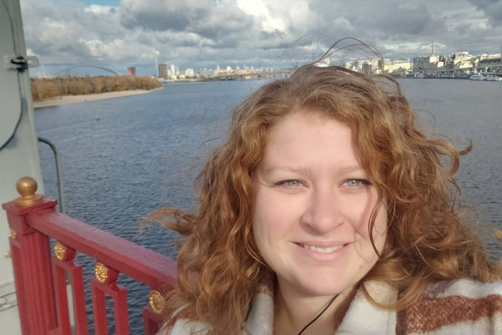 Nicole Jepeal (CAS’11) on Park Bridge, which crosses the Dnieper River in Kyiv, with both banks of the city sprawling behind her. Photo courtesy of Nicole Jepeal