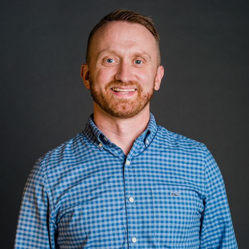 Photo of Steve Holt, a white man with very short hair and a gingery beard. He has blue eyes, smiles, and wears a blue button down shirt.