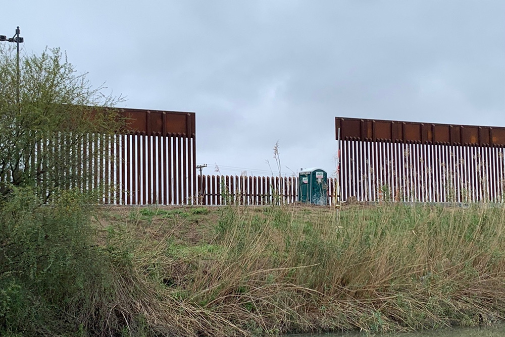Photo: A section of the border wall/fence in Rio Grande. the middle section is much shorter than the sections on the left and right of it.