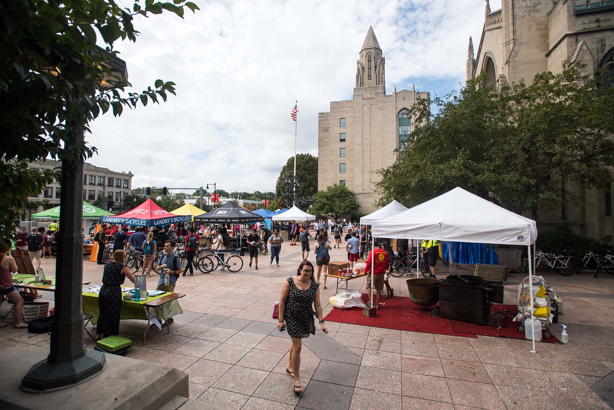 Photo of the BU Sustainability Festival. Various open tents and booths are shown set up around Marsh Plaza on Commonwealth Ave. Various students and people congregate and interact at booths featuring giveaways, farmer's markets, and plants.