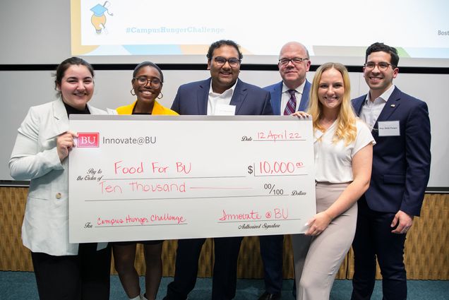 Photo of the winning hunger challenge team posing with a giant $10,000 check and Congressman Jim McGovern. From left: Alexia Lancea (CAS’22), Eunice Lamothe (CAS’22, SPH’23), Saahil Adusumilli (Sargent’22), and Mary Campion (CAS’22), US Rep. Jim McGovern, and State Rep. Andy Vargas.